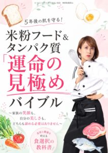 Japanese book cover with a woman in a chef coat holding a whisk, bold black and pink Japanese title about米粉フード and運命の見極め, with bread, eggs and vegetables illustrations